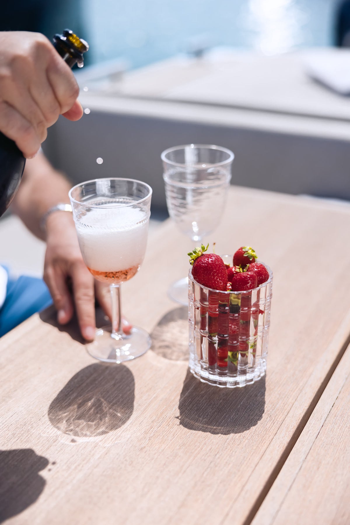 Zwei Gläser gekühlter Rosé und ein Glas Erdbeeren auf dem Hecktisch